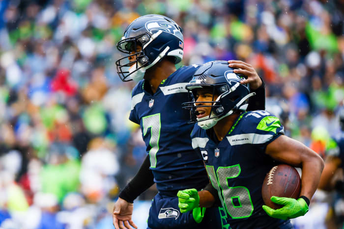Geno Smith puts his hand on Tyler Lockett’s helmet